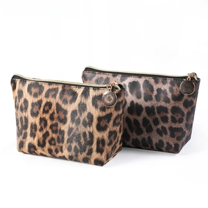 Detail showing two leopard print cosmetic bags with gold zippers and premium PU leather texture