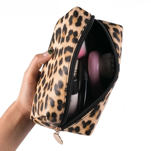 Detail of leopard print makeup bag interior with brushes and gold zipper closure
