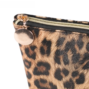 Detailed close-up of leopard print makeup bag with gold zipper and metal hardware