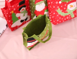 Dettaglio dei sacchetti regalo di Natale in feltro con Babbo Natale e pupazzo di neve 3D