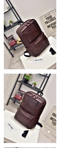 Detail of dark brown faux leather backpack with textured surface and wide handle