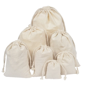 Detailed view of natural cotton drawstring bags in various sizes with durable fabric texture