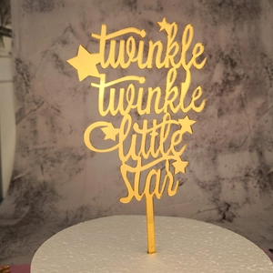 Close-up of golden mirror acrylic cake topper with twinkle twinkle little star lettering