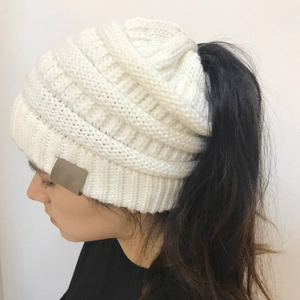Detail of white chunky knit ponytail beanie showing the top hole for hair styling