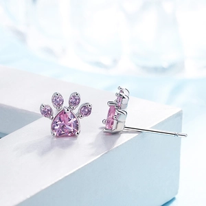 Macro detail of pink zircon cat paw studs showing heart-shaped stones and silver plating