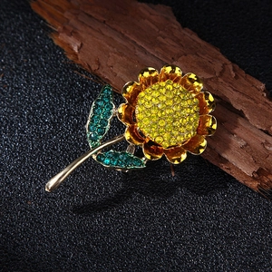 Macro shot of gold sunflower brooch featuring sparkling yellow and green rhinestones