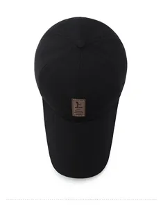 Top down view of black cotton canvas baseball cap with brown leather EDIKO patch