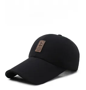 Close-up of black baseball cap featuring a premium brown leather logo patch on the front