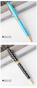 Detail view of metal ballpoint pen with cute polka dot pattern, elegant office stationery.
