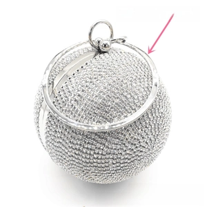 Detail of silver round evening clutch with sparkling rhinestones and metal ring handle