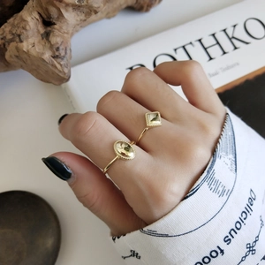 Detail of 925 silver adjustable geometric rings in gold finish worn on hand