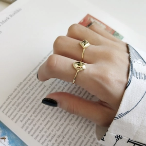 Detail of adjustable gold geometric rings with square and oval minimalist designs