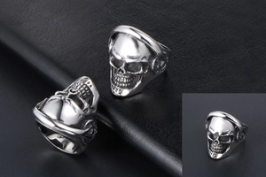 Close-up of punk skull ring with black eyes on a textured leather background
