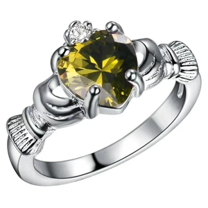 Silver Claddagh ring featuring a green heart gemstone and crown detail on white background