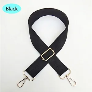 Detail of adjustable black nylon bag strap with gold metal lobster clasps and buckles
