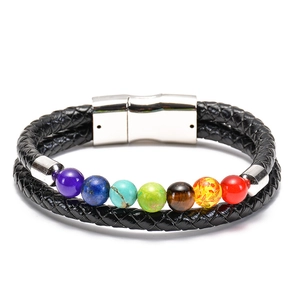 Dettaglio di perle in pietra naturale su bracciale in pelle nera intrecciata con chiusura magnetica