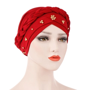 Detail of red turban cap with braided headband and golden floral beadwork decoration