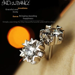 Macro shot of silver snowflake earrings with sparkling round cubic zirconia stones