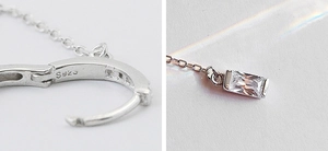 Macro shot of S925 sterling silver earring hoop with rectangle zircon pendant detail