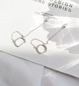 Detail of silver drop earrings with sleek chains and sparkling cubic zirconia stones