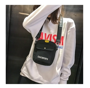 Close-up of black canvas crossbody bag with white letter print and wide strap detail