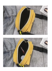 Detail view of the yellow canvas crossbody bag interior capacity with phone and compact