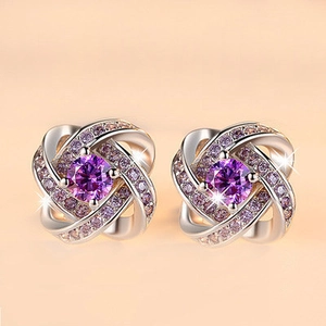 Detailed view of silver knot earrings featuring sparkling purple round gemstones and accents