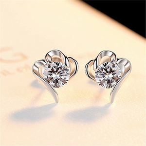 Macro shot of silver heart-shaped stud earring featuring a brilliant sparkling zircon