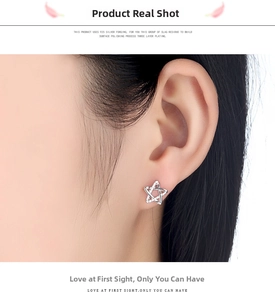 Detailed view of silver star earrings in 925 sterling silver worn on an earlobe