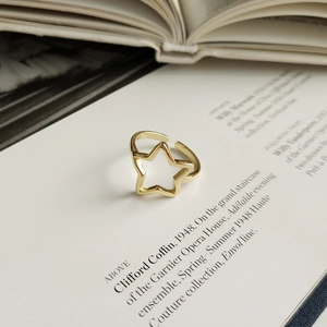 Dettaglio dell'anello dorato con stella traforata su un libro d'epoca raffinato