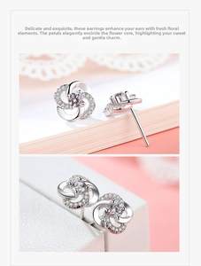 Macro detail of silver flower earrings with center zircon and micro-pave diamond petals