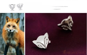 Macro detail of 925 sterling silver fox earrings on a premium purple velvet background