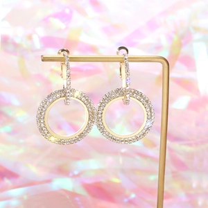 Macro detail of geometric hoop earrings featuring full pavé diamonds on gold plating