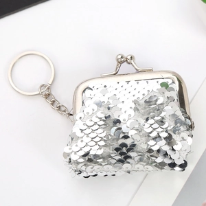 Detail van een mini zilveren pailletten portemonnee met vintage sluiting en een sleutelhanger