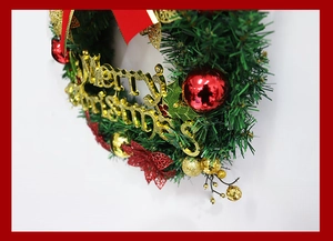 Detail of Christmas wreath with red and gold balls and Merry Christmas lettering