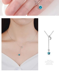 Detailed view of silver necklace with blue star pendant and sparkling moon element