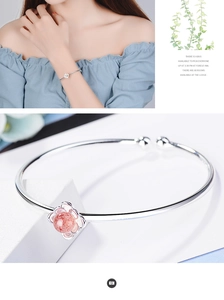 Dettaglio di un bracciale regolabile in argento con pendente a fiore rosa e cristallo