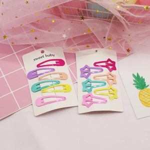 Macro view of candy-colored metal hair clips in star and oval shapes on display card