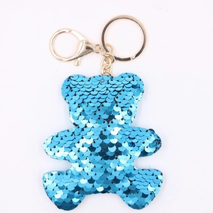 Detailed view of a blue sequin teddy bear keychain with a polished gold metal clasp