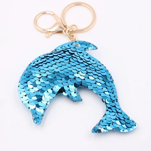 Blue sequin dolphin keychain with gold metal ring and clasp on a white background