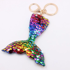 Close-up of a mermaid tail keychain with vibrant sequins and a golden metal ring