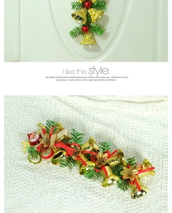Detail of Christmas bell ornament with green pine needles and red ribbon bow decoration