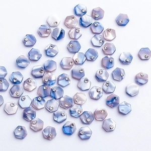 Hexagonal marble texture nail art charms with sparkling crystals on white background