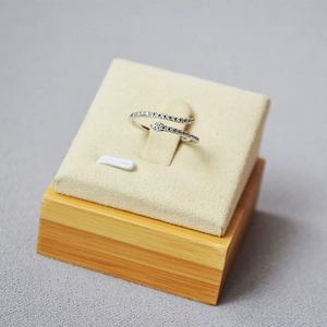 Macro shot of silver snake ring with pavé crystals on a wooden jewelry stand