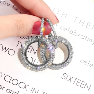 Macro view of crystal encrusted silver hoop earrings with shimmering brilliant stones