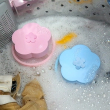 Plum-shaped lint catcher floating in a washing machine to collect hair and debris