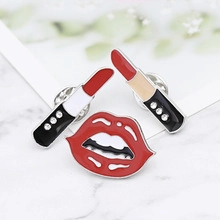 Macro shot of vintage enamel lipstick and red lip brooches with gold trim and rhinestones