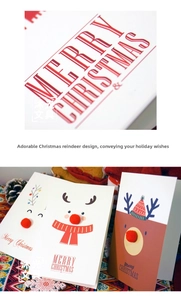 Close-up of a 3D red pompom elk nose detail on a creative Christmas card with pine cones