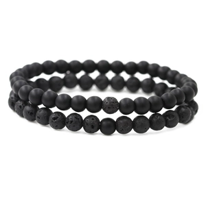 Set of 2 matte black beads and lava stone distance bracelets for couples on white background