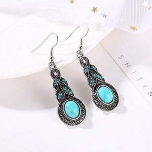 Détail macro de boucles d'oreilles bohèmes vintage en argent avec cristal bleu et turquoise